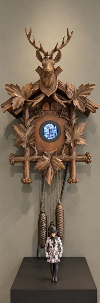 "Upgrade Your Time ©Germany" Single-channel video installation in a modified cuckoo clock | Objet trouvé with integrated monitor, Figure, video and synchronized sound reproduction in end loop Object: Unique Integrated video work: edition of 5 2026